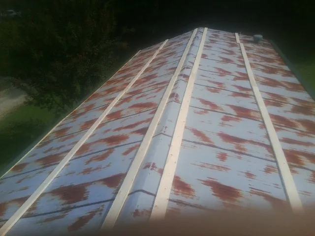 Rusted metal roof panels with new wood purlins before replacement — Storm Damage Roof Repair in Essex Fells by Roofing Brothers