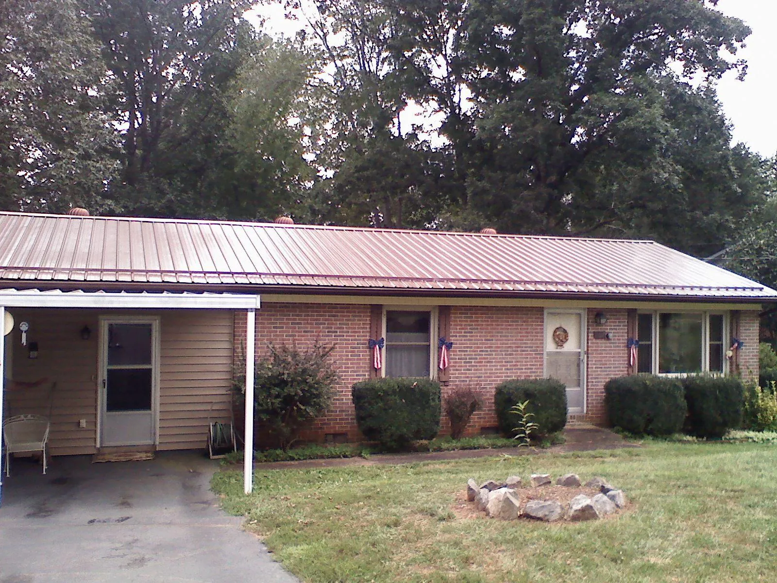 Bronze metal roof and carport on a brick ranch home — Roof Repair work by our crew in Essex Fells